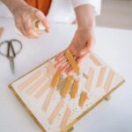 Close-up of crafting wooden wicks with a spray bottle, highlighting attention to detail and craftsmanship.